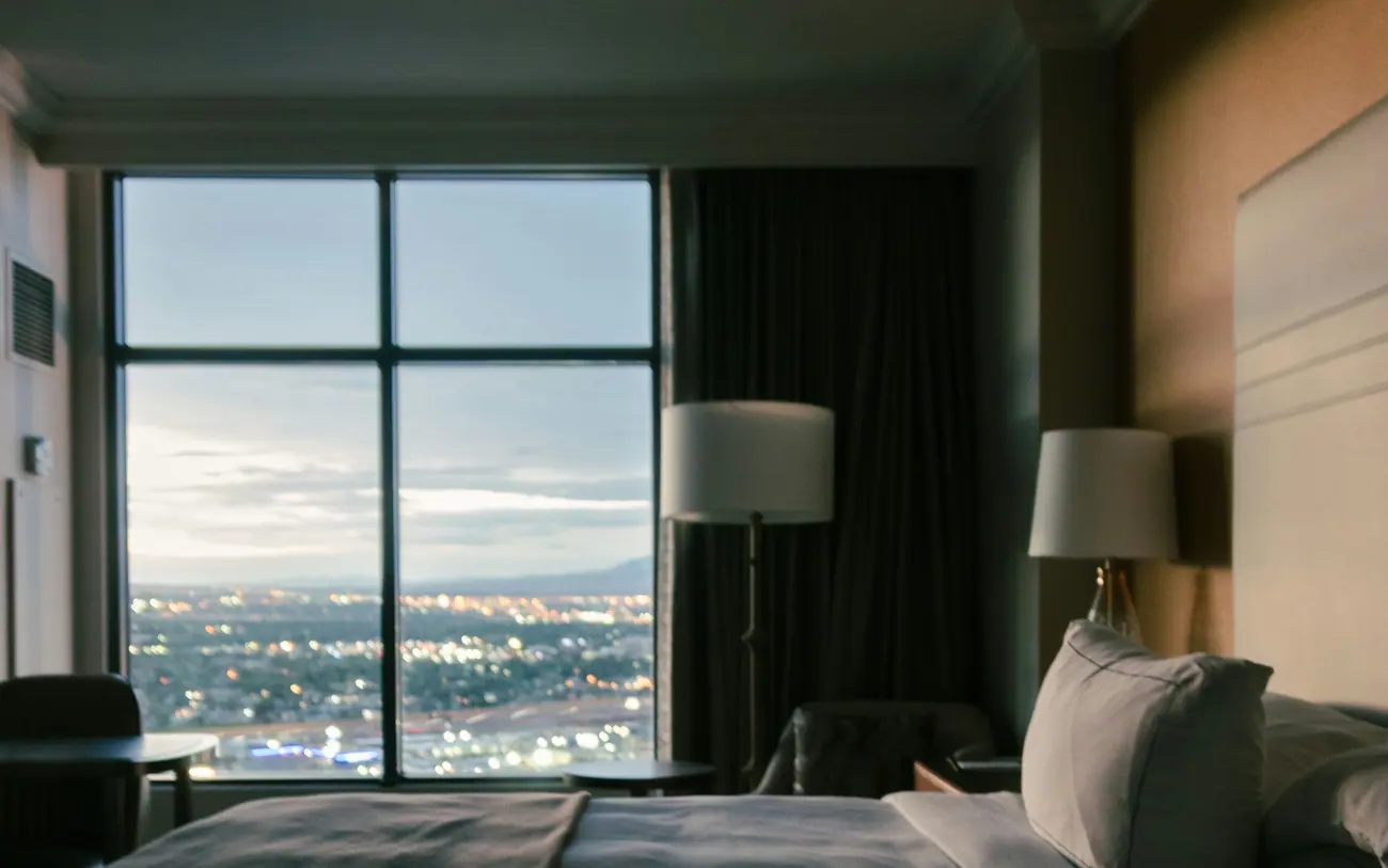 Hotel room with a bed and a window view over the city